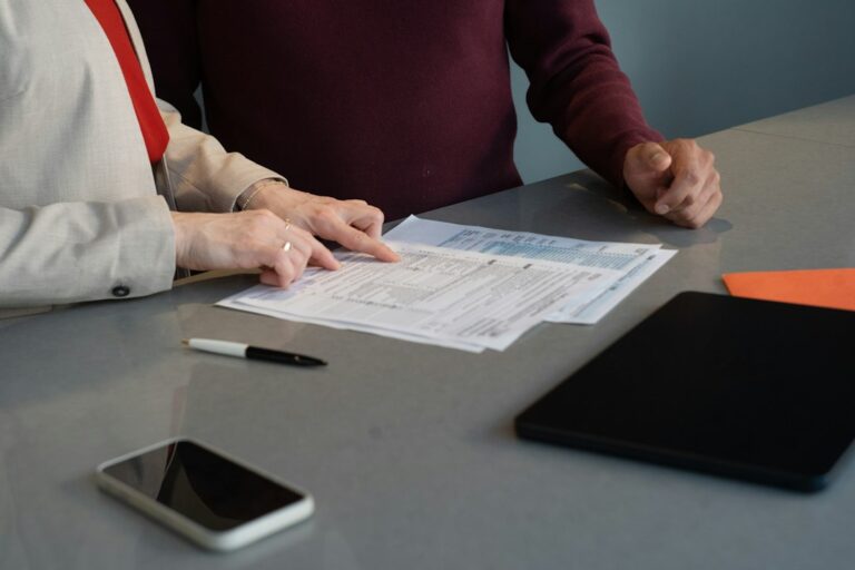 Two people reviewing paperwork at a meeting table